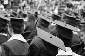 Graduates seated with caps at ceremony.