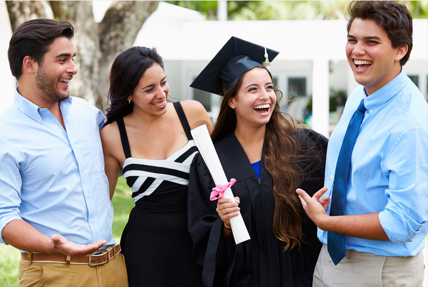Graduation celebration with friends outdoors, smiling joyfully.