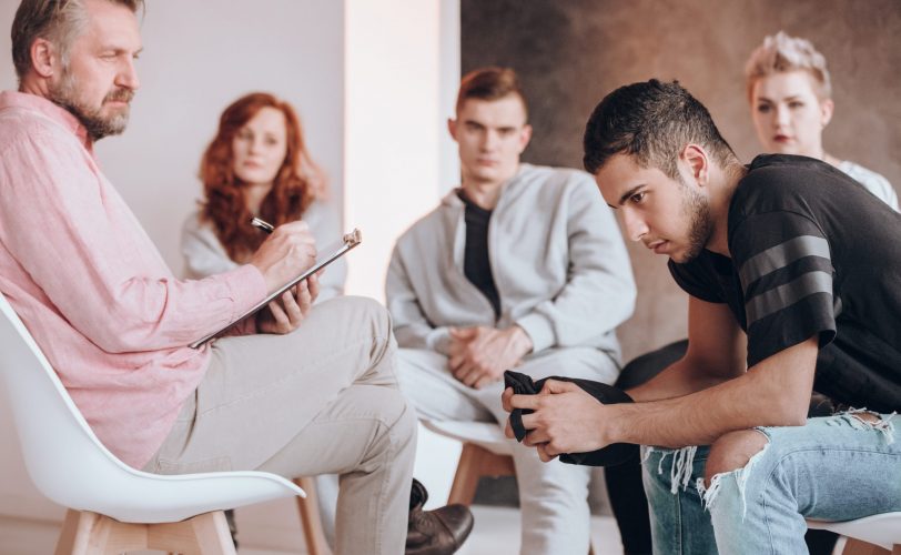 Group therapy session with people discussing. Group therapy session with people discussing.
