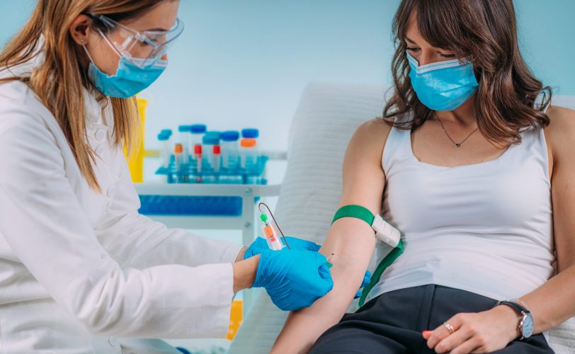 Healthcare worker drawing blood from patient. Healthcare worker drawing blood from patient.