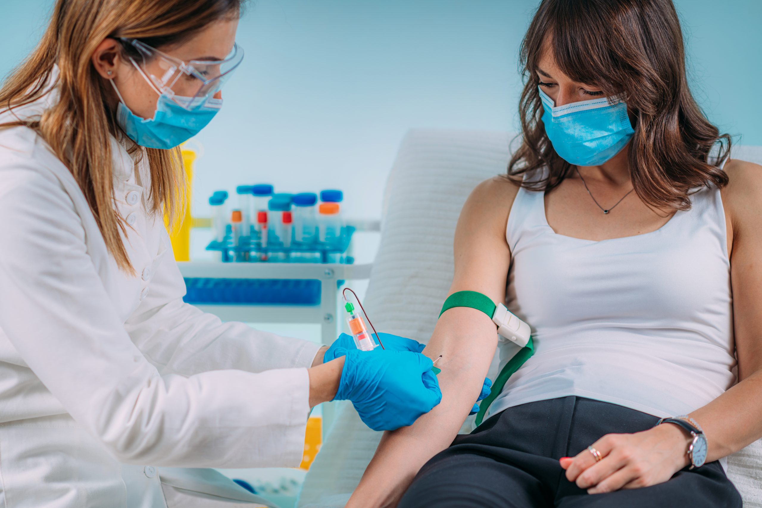 Healthcare worker drawing blood from patient.